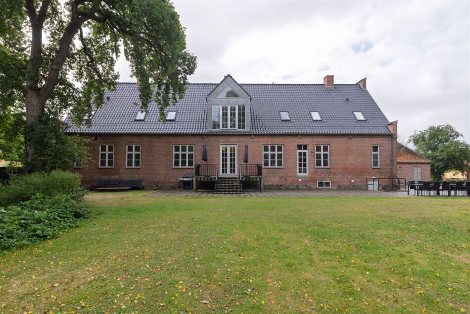 Bagfacade, græsplæne og terrasse